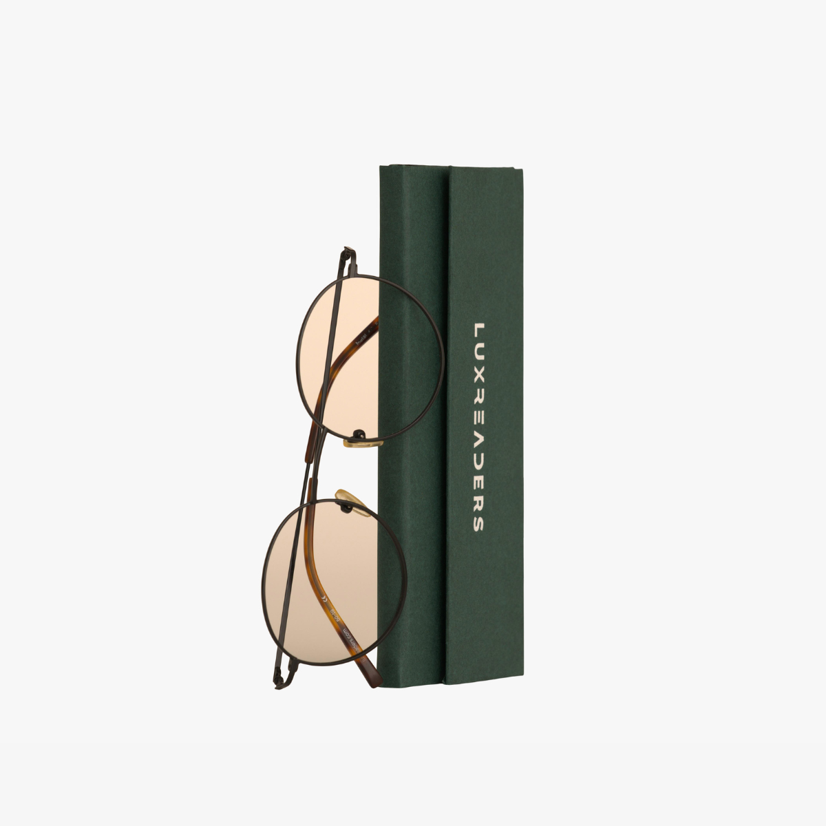 Round glasses with bronze frame and tinted lenses, next to Luxreaders hard case